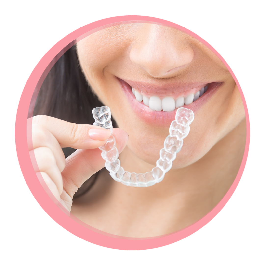 woman smiling holding Invisalign clear aligner